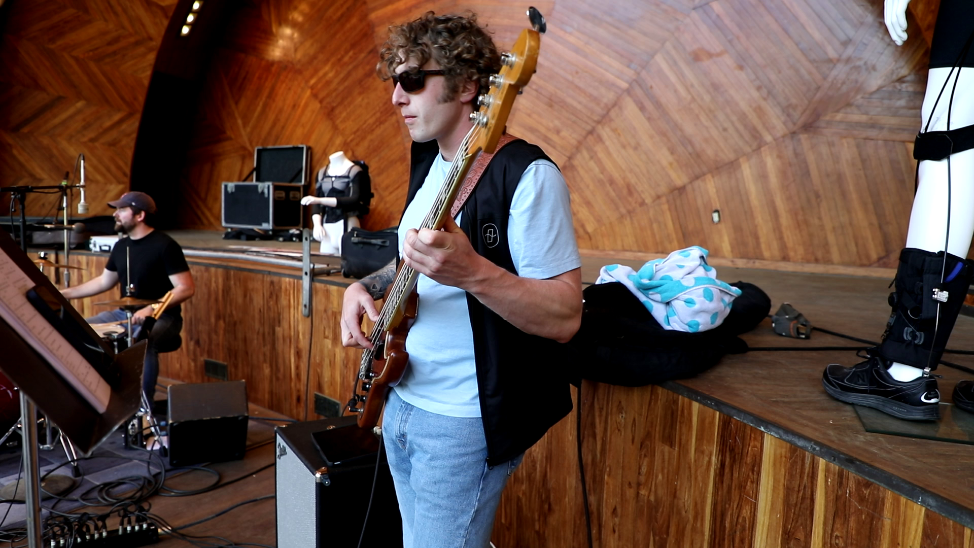A bassist performing on stage at an outdoor Hatch Shell concert